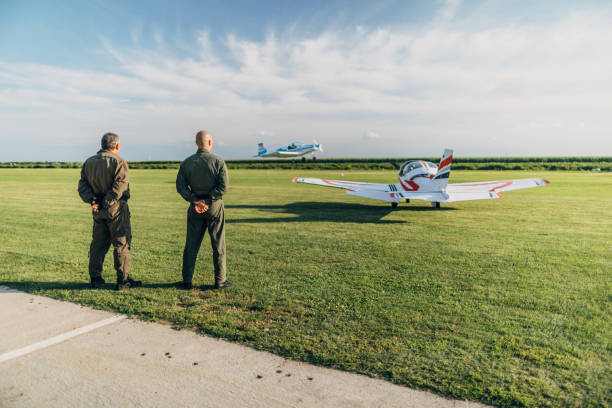 istock Two pilots standing by the propeller airplane 1187353447