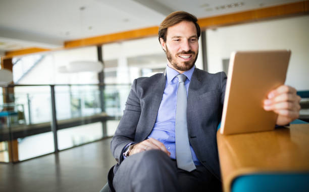 istock Young handsome business man using a digital tablet at office 1187353923