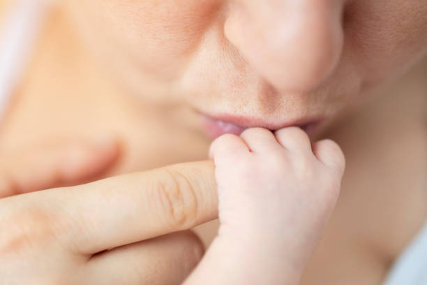 istock Loving mother kiss her baby's hand 1187354685