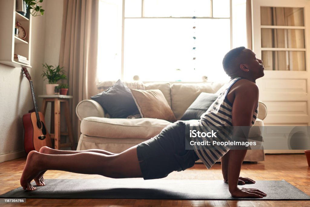 Yoga is for everyone Shot of a young man practising yoga at home during the day Yoga Stock Photo