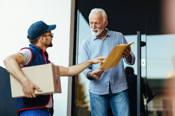 istock Senior man talking to a courier while receiving home delivery. 1187354891