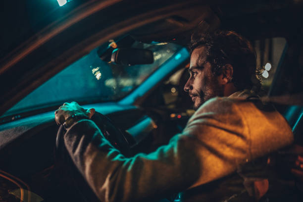 istock Man driving a car at night 1187355167