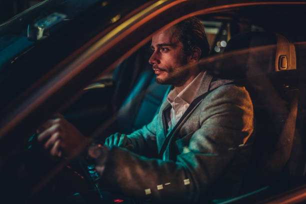 istock Modern man driving a car at night 1187355991