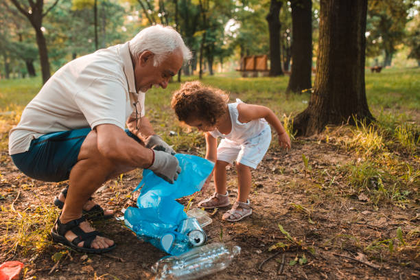дедушка и его внучка поддержанию окружающей среды в чистоте - sustainable resources environment education cleaning стоковые фото и изображения