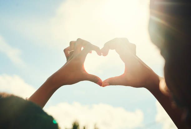 Cropped shot of an unrecognizable couple forming a heart shape with their hands