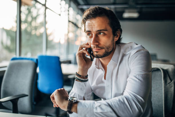 istock Handsome businessman talking on mobile in office 1187356506