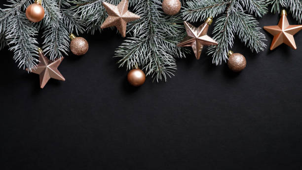 istock Christmas banner. Xmas tree branches decorated cooper stars and balls on black background. Flat lay, top view, copy space. New year, winter holidays, Christmas concept. 1187357384
