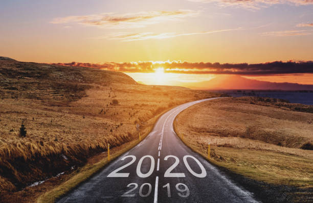 istock 2020 and 2019 on the empty road at sunset. New Year concepts 1187358250