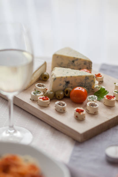 Close up of different kind of cheese on cutting board.