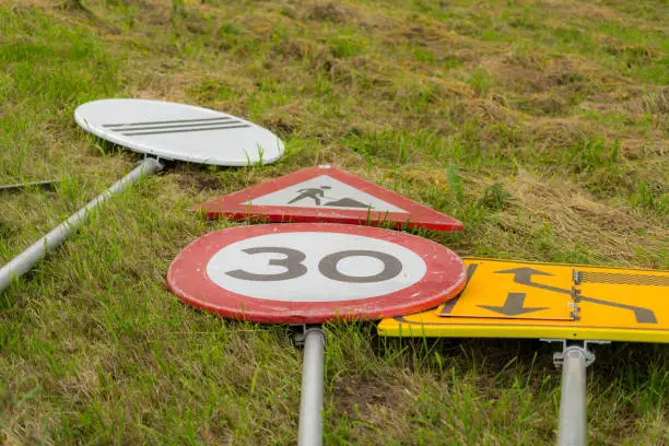 Unused traffic signs on the grass near the road