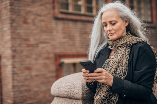istock Beautiful mature lady using mobile on the street 1187360717