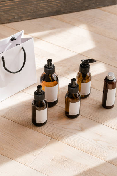 bottiglie cosmetiche ambrate scure su tavolo di legno - merchandise luxury still life spa treatment foto e immagini stock