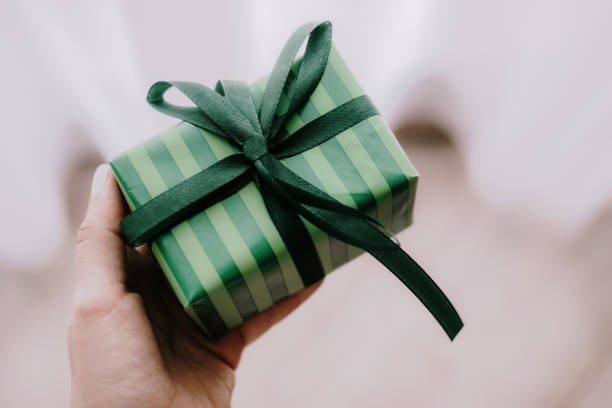 istock Woman holding green color gift box 1187362502