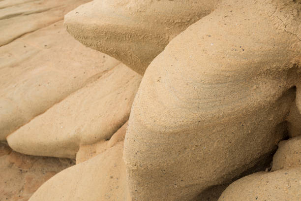 Detail of the red, orange and yellow sand stone cliffs of a rocky shore or beach on the Greek Island of Chios in the Aegean Sea in the diffused light of a cloudy morning in winter. Many refugees travelling from Turkey to Greece have landed on this particular beach. The image was captured with a full frame DSLR camera with a fast sharp lens at low ISO resulting in a large, clean file.