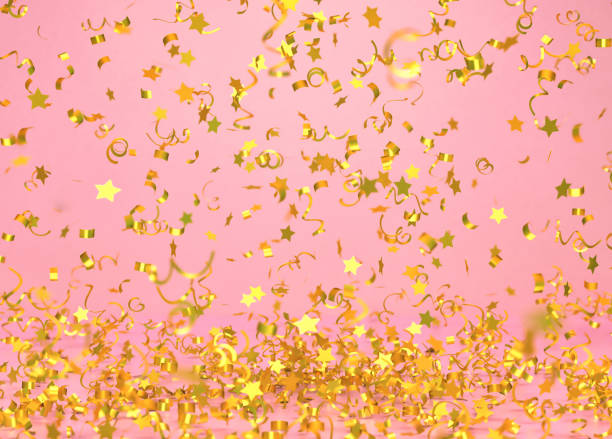 istock Golden confetti falling on pink background 1187363382