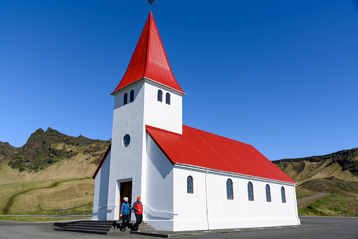 A couple on the stairs in front of the church in Vik.