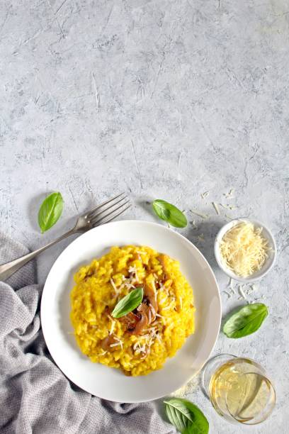 traditionelles italienisches risotto mit pilzen, safran und parmesankäse mit weißwein. - parmesan cheese risotto rice basil stock-fotos und bilder