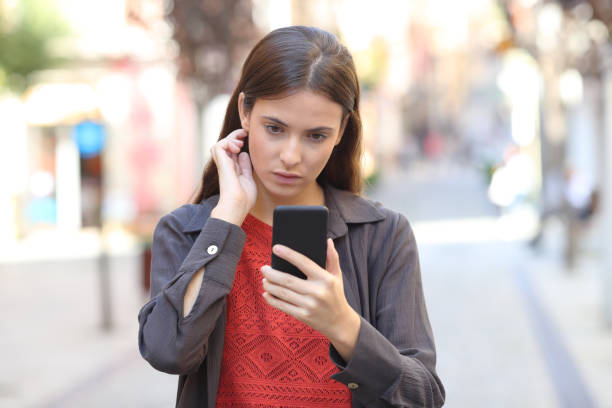 istock Serious girl using mobile phone touching hair 1187366451
