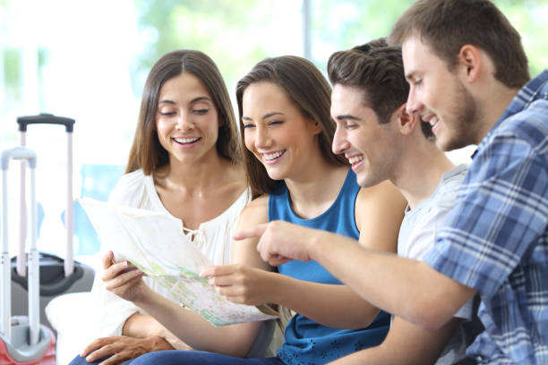istock Group of tourists planning vacation checking maps 1187367146