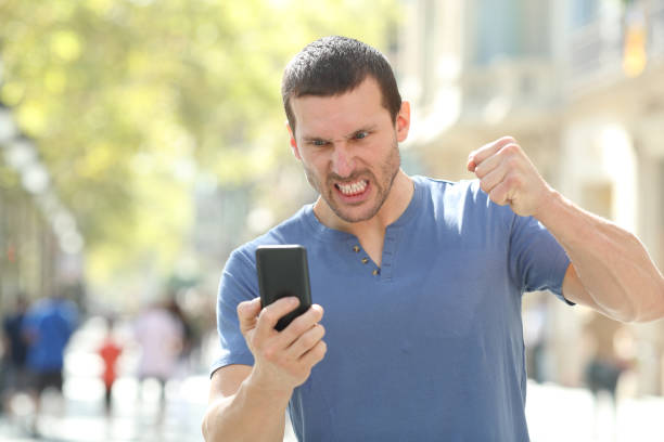 istock Angry man checking crashed smart phone in the street 1187367252