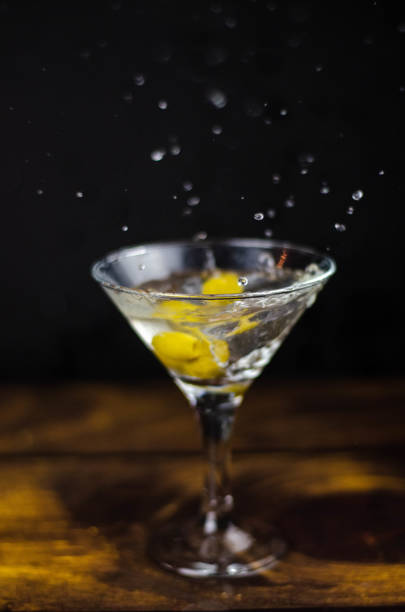 istock Martini glass with olive splash on dark background 1187367293