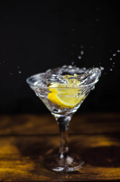 istock Martini glass with lemon splash on dark background 1187367295
