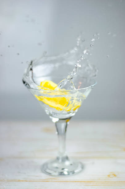 istock Martini glass with lemon splash on light background 1187367300