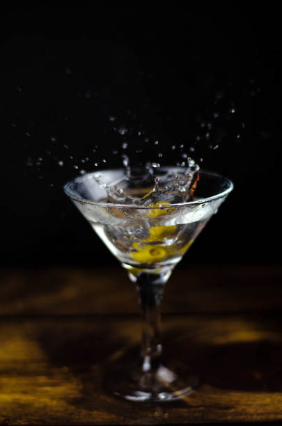 istock Martini glass with olive splash on dark background 1187367307