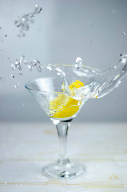 istock Martini glass with lemon splash on light background 1187367314