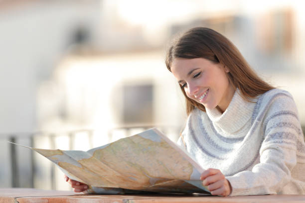 istock Happy tourist checking a paper map in winter 1187367528