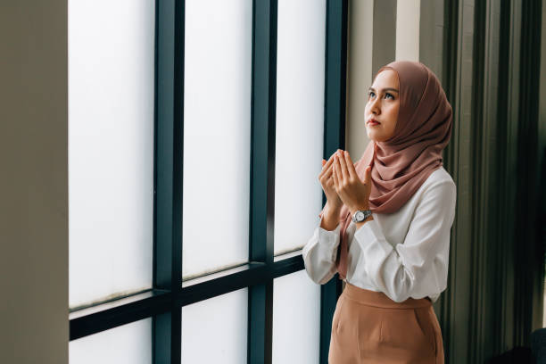 istock Islamic woman praying near window 1187368584