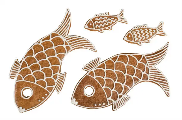 Photo of Ornate hand painted gingerbread fishes isolated on a white background. Fragrant confections detail