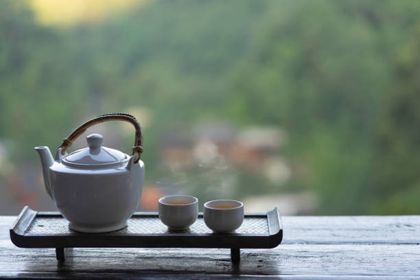 Hot tea in teapot and cup on wood table nature view.