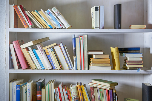 Messed  up bookshelf in white wall