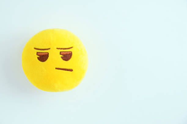 istock Yellow round soft toy sad emoticon on a white background. 1187373557