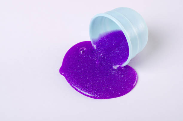 istock Making slime yourself. Ingredients for making bright glittering slime at home. Violet slime spills on a table from plastic container. 1187377660