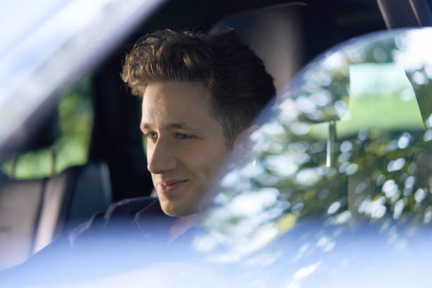 istock Young attractive driver in a car driving in greenery 1187389083