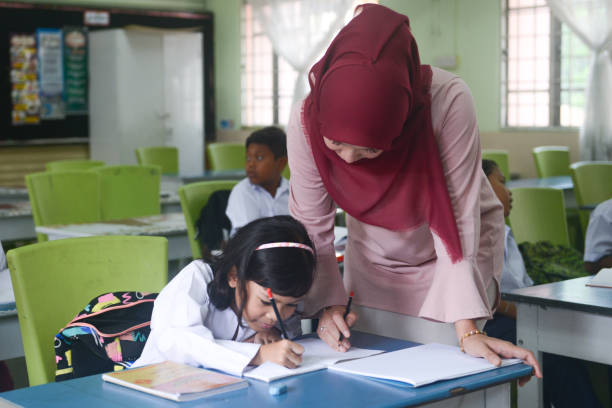 istock Asian female teacher in hijab teaching elementary students in classroom 1187393754