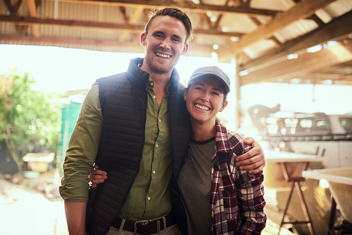 Portrait of a happy young couple posing together at their farm