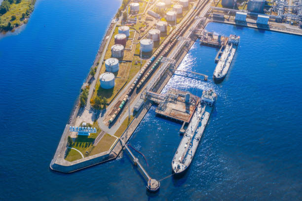 vista aérea gran terminal de carga de aceite de puerto con grandes tanques de almacenamiento. infraestructura ferroviaria para la entrega de carga a granel por mar - buque tanque petrolero fotografías e imágenes de stock