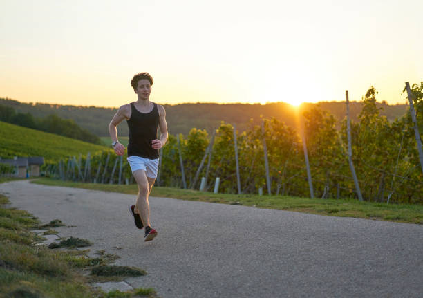 istock Young runner in the vineyards in shorts with backlight 1187397938