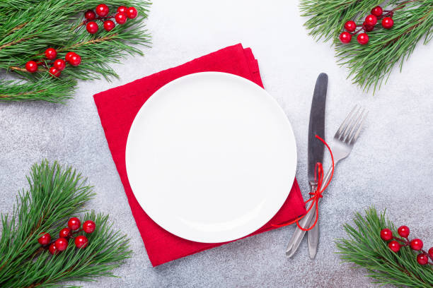 istock Christmas table place setting with empty white plate, cutlery with festive decorations on stone background 1187398784