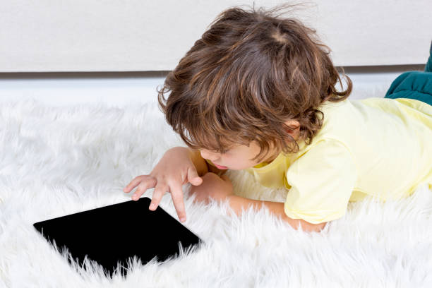 istock Little Boy working tablet on carpet 1187400362