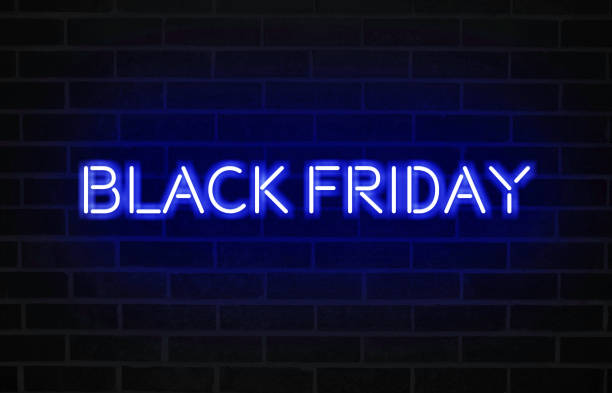 istock Black Friday text with bright red neon font on blacked brick wall 1187400407