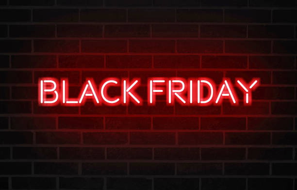 istock Black Friday text with bright red neon font on blacked brick wall 1187400612