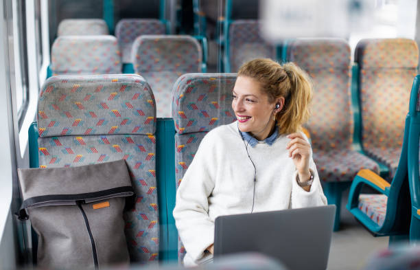 istock Young Woman Commuting by Train, Working on Laptop 1187400817