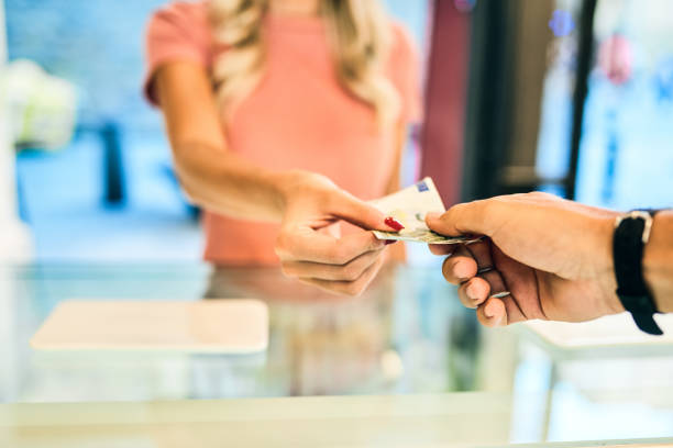 Cash is still alive and well Shot of a woman paying at the checkout of an ice cream parlour with Euros franchising photos stock pictures, royalty-free photos & images