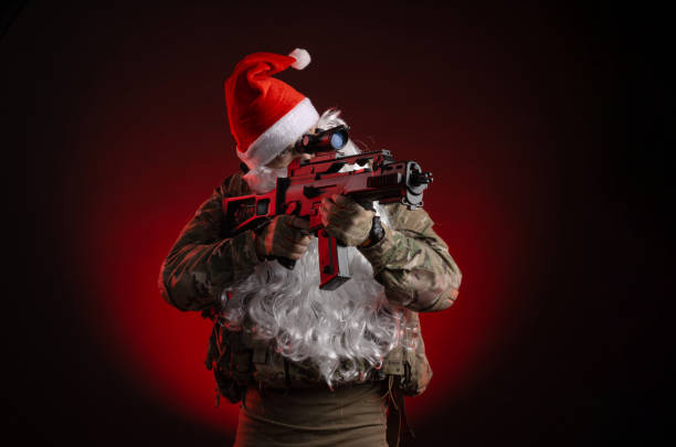 a man in a military uniform with a gun and a santa claus hat - airsoft gun imagens e fotografias de stock