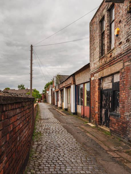 Grey clouds over a small road with rundown houses, seen in Carlisle, Cumbria, England, UK