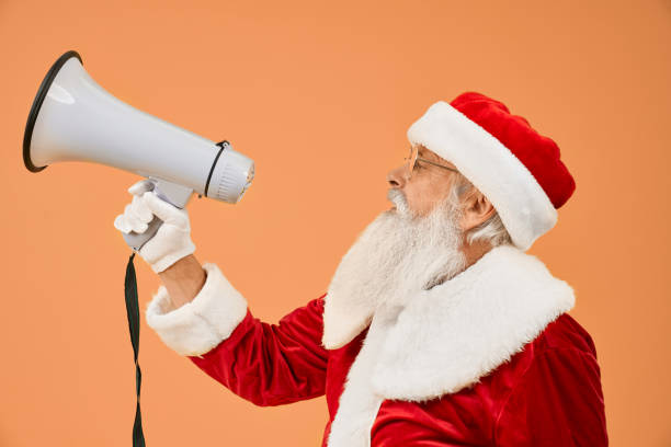 istock Side view of senior Santa Claus talking with megaphone 1187406840